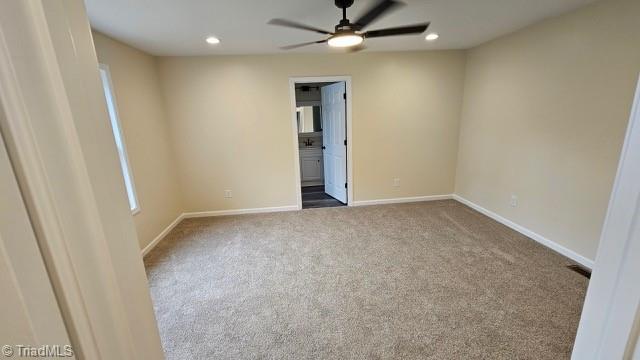 carpeted spare room featuring ceiling fan