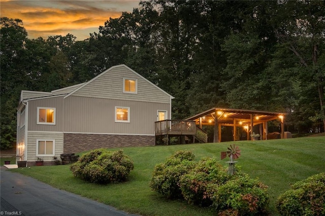 exterior space with a deck and a lawn