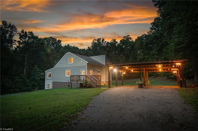 view of front of house with a porch, a yard, and a carport