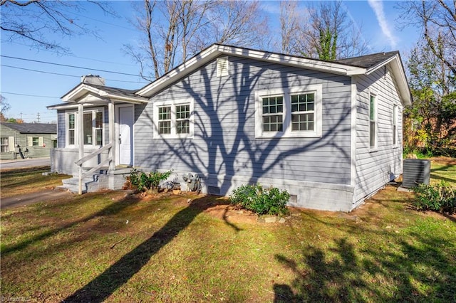 view of front of property featuring a front yard and central AC unit