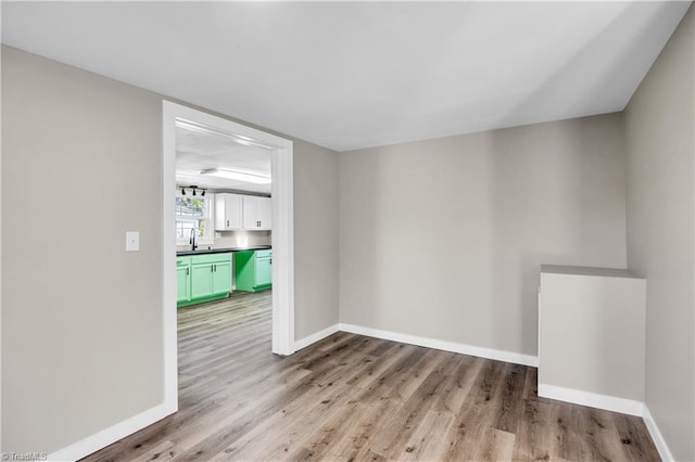 spare room with light wood-type flooring and sink