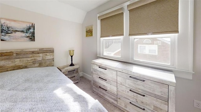 bedroom with light carpet and lofted ceiling