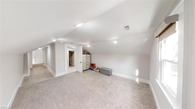 bonus room with light colored carpet and lofted ceiling