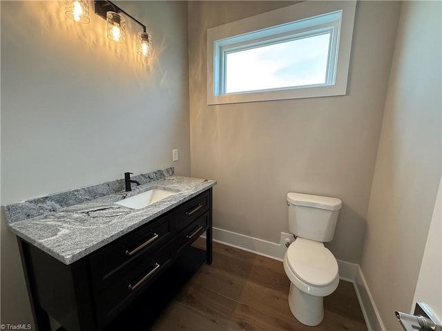 3048 Island Dr, Northtopsail Beach, NC 28460 - bathroom featuring baseboards, wood finished floors, toilet, and vanity