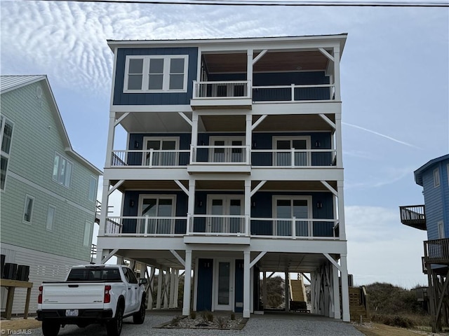 3048 Island Dr, Northtopsail Beach, NC 28460 - beach home featuring gravel driveway, a carport, and board and batten siding