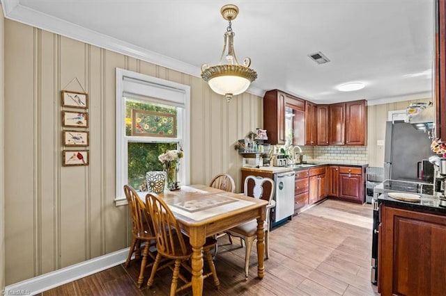 3941 Vest Mill Rd, Winston-Salem, NC 27103 - kitchen with stainless steel appliances, healthy amount of natural light, crown molding, decorative backsplash, and light wood-style flooring