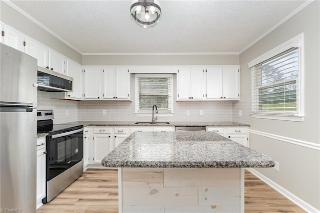 4104 Old Greensboro Rd, Winston-Salem, NC 27101 - kitchen with appliances with stainless steel finishes, a sink, ornamental molding, healthy amount of natural light, and light stone countertops