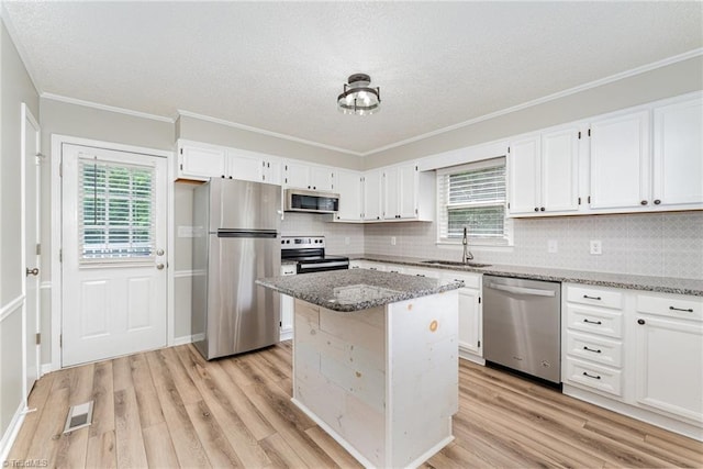4104 Old Greensboro Rd, Winston-Salem, NC 27101 - kitchen featuring appliances with stainless steel finishes, a sink, light stone countertops, plenty of natural light, and a textured ceiling