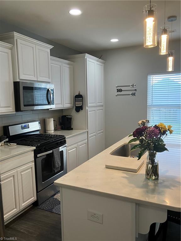 5304 Smoky Ridge Ln, Winston-Salem, NC 27127 - kitchen featuring appliances with stainless steel finishes, light countertops, a kitchen island with sink, white cabinets, and recessed lighting