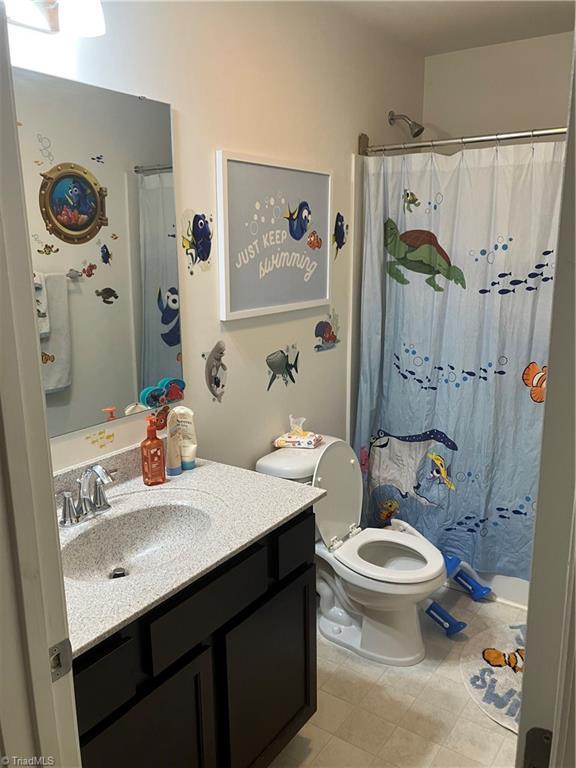 5304 Smoky Ridge Ln, Winston-Salem, NC 27127 - bathroom with vanity, toilet, and curtained shower