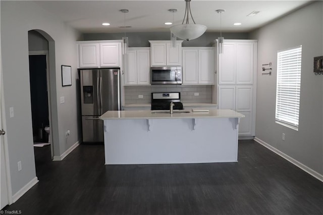 5304 Smoky Ridge Ln, Winston-Salem, NC 27127 - kitchen with appliances with stainless steel finishes, arched walkways, light countertops, baseboards, and decorative backsplash