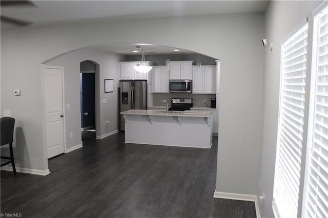 5304 Smoky Ridge Ln, Winston-Salem, NC 27127 - kitchen featuring stainless steel appliances, arched walkways, a kitchen breakfast bar, white cabinetry, and light countertops