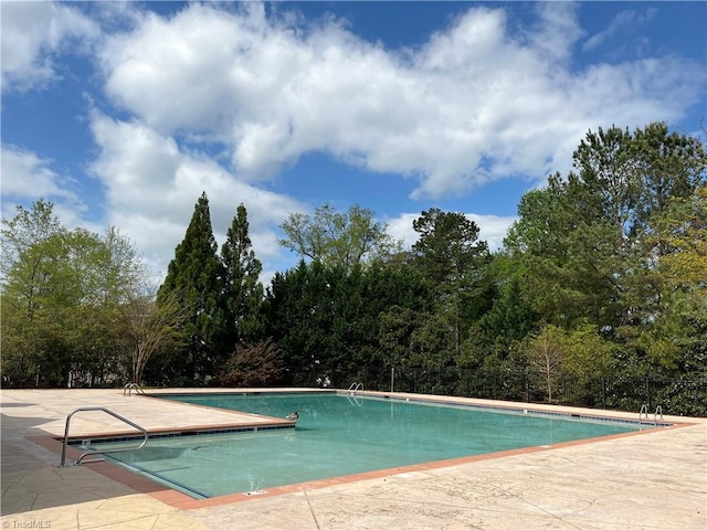 pool with a patio and fence