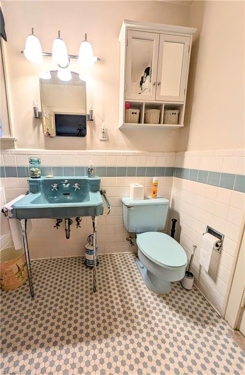 bathroom featuring tile walls, tile patterned floors, and toilet