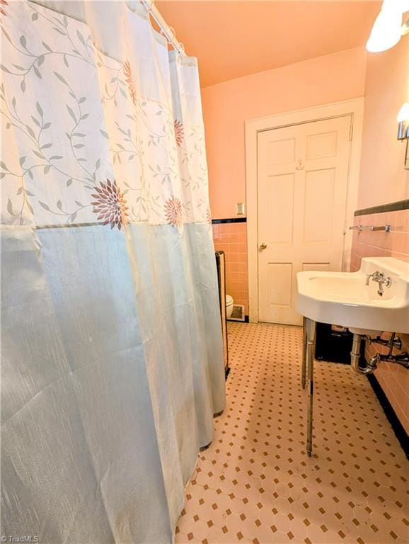 bathroom featuring tile walls and sink