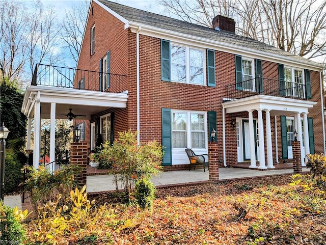 back of house featuring ceiling fan and a balcony