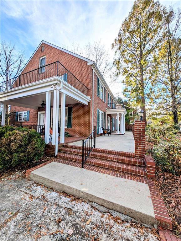 view of property exterior with ceiling fan, a balcony, and covered porch