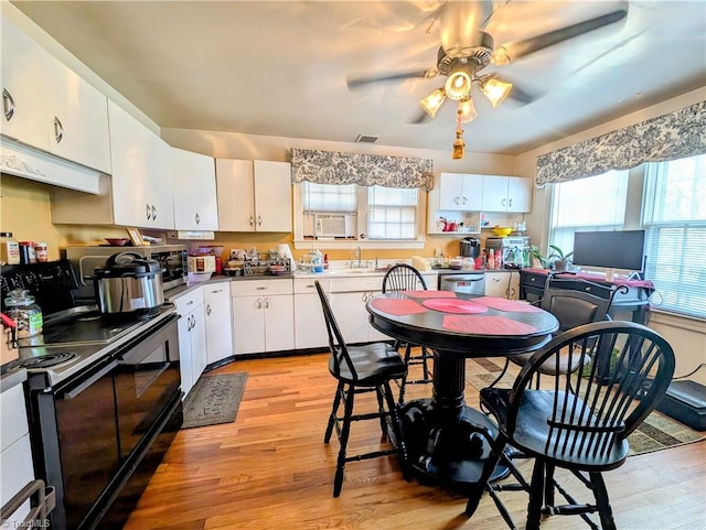 kitchen with stainless steel appliances, light hardwood / wood-style floors, and white cabinets