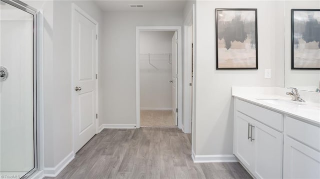 2124 Monk Dr, Haw River, NC 27258 - full bathroom with wood finished floors, a stall shower, vanity, a spacious closet, and baseboards