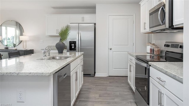 2124 Monk Dr, Haw River, NC 27258 - kitchen featuring stainless steel appliances, a sink, white cabinets, light wood-style floors, and a center island with sink