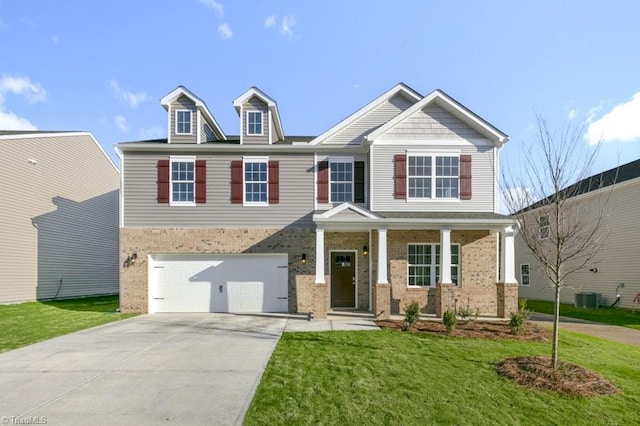 craftsman inspired home with brick siding, a front yard, a porch, and driveway