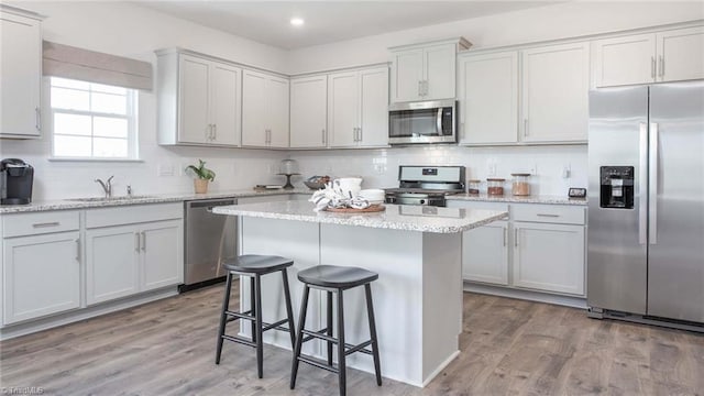 kitchen featuring light wood-style floors, tasteful backsplash, and stainless steel appliances