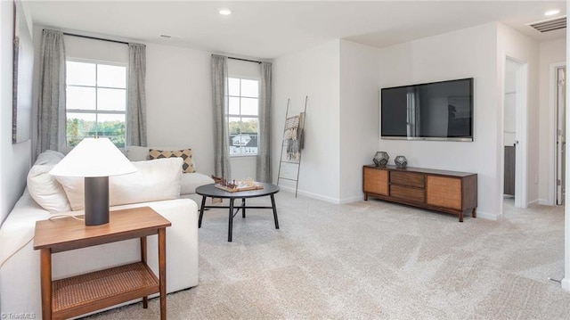 living room featuring recessed lighting, light colored carpet, visible vents, and baseboards