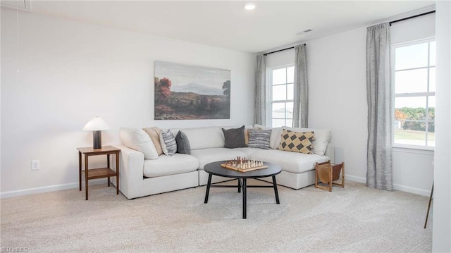 living room featuring carpet flooring, attic access, and baseboards