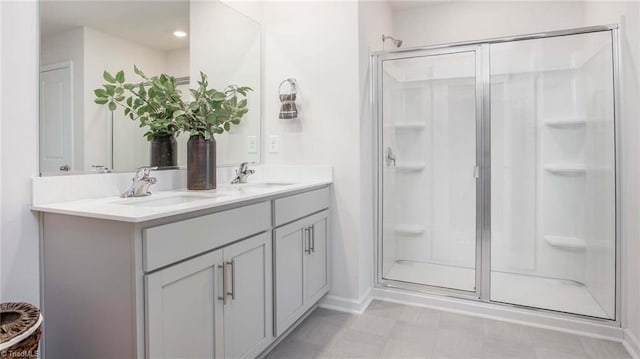 bathroom featuring a sink, double vanity, and a shower stall