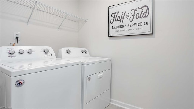 washroom with baseboards, laundry area, and washing machine and clothes dryer