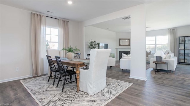 dining room featuring visible vents, wood finished floors, and a fireplace