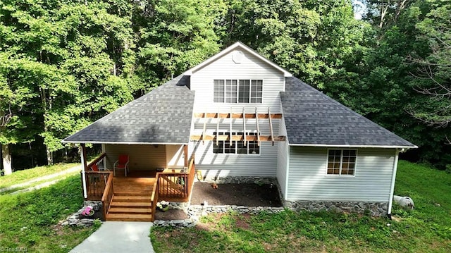 view of front of house featuring a shingled roof and a front lawn