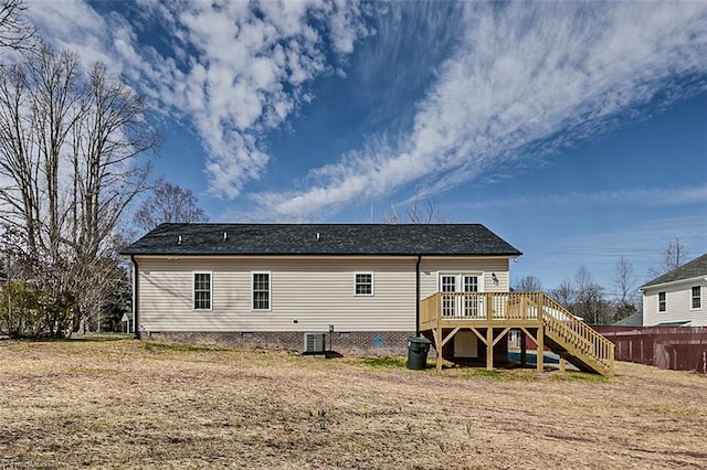 rear view of property featuring stairs, crawl space, a wooden deck, and a lawn