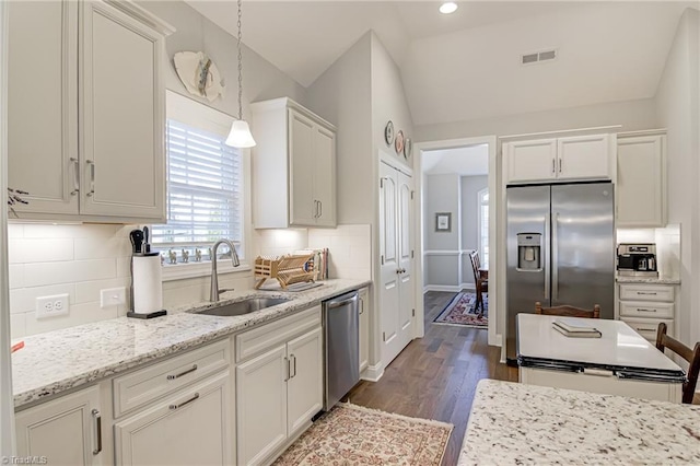 kitchen with sink, decorative light fixtures, backsplash, and appliances with stainless steel finishes