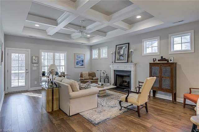 living room with beamed ceiling, wood-type flooring, plenty of natural light, and coffered ceiling