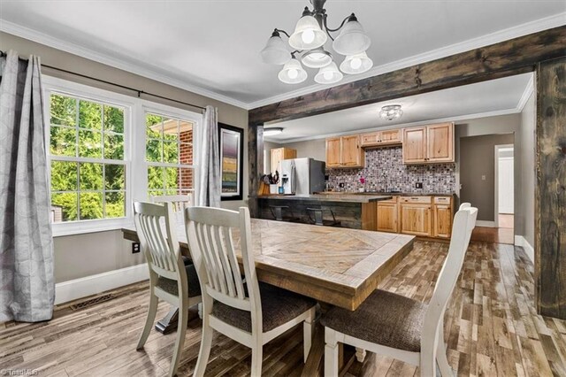 407 Pinedale Dr, Reidsville, NC 27320 - dining room featuring a chandelier, light wood-style floors, healthy amount of natural light, and ornamental molding