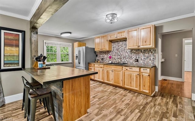 407 Pinedale Dr, Reidsville, NC 27320 - kitchen with stainless steel fridge with ice dispenser, ornamental molding, light wood-style floors, a kitchen breakfast bar, and decorative backsplash
