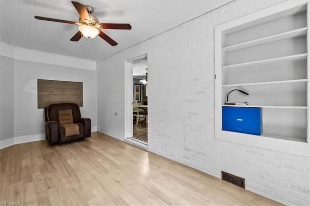 407 Pinedale Dr, Reidsville, NC 27320 - unfurnished room with ceiling fan, wood finished floors, brick wall, and built in shelves