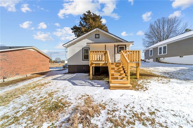 snow covered house with a deck