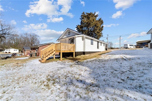 view of snow covered exterior with a deck