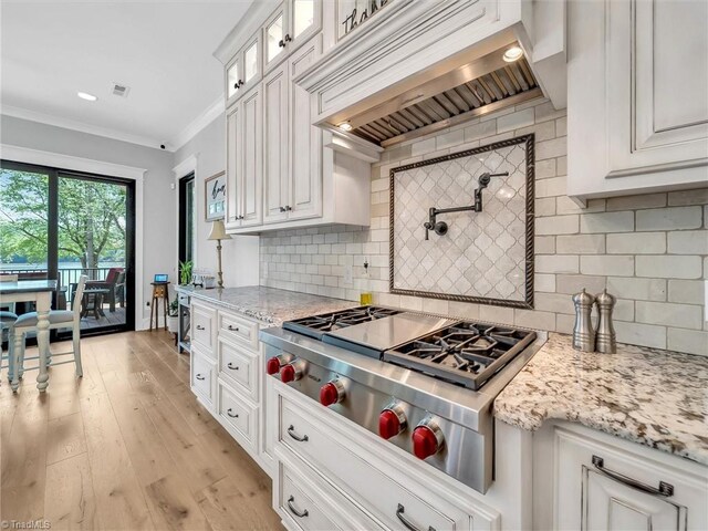 1579 Sunset Pointe Dr, Salisbury, NC 28146 - kitchen with stainless steel gas stovetop, decorative backsplash, glass insert cabinets, custom range hood, and white cabinetry