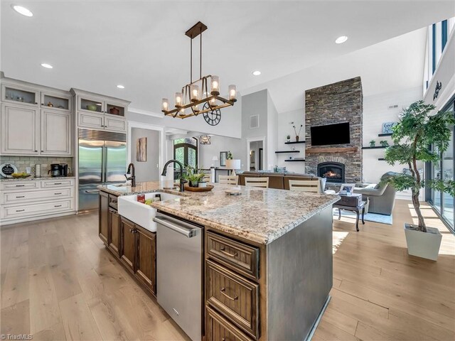 1579 Sunset Pointe Dr, Salisbury, NC 28146 - kitchen with a sink, open floor plan, a center island with sink, a fireplace, and appliances with stainless steel finishes