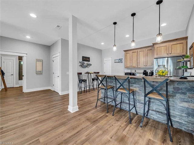 1579 Sunset Pointe Dr, Salisbury, NC 28146 - kitchen with light wood-type flooring, baseboards, freestanding refrigerator, recessed lighting, and pendant lighting