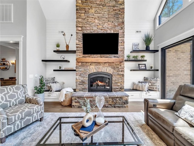 1579 Sunset Pointe Dr, Salisbury, NC 28146 - living area with high vaulted ceiling, a stone fireplace, wood finished floors, and visible vents