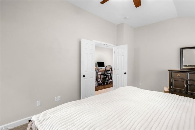 carpeted bedroom with lofted ceiling, baseboards, ceiling fan, and a desk