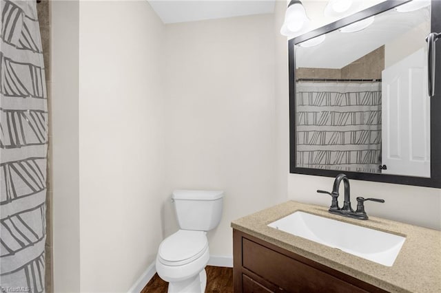 bathroom featuring toilet, vanity, wood finished floors, baseboards, and a shower with shower curtain