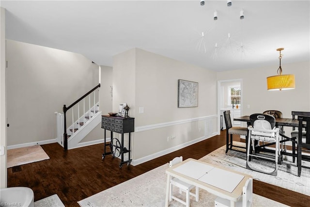 dining area with wood finished floors, stairway, and baseboards