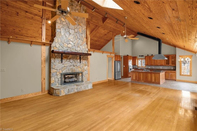 unfurnished living room with wood ceiling, ceiling fan with notable chandelier, and light hardwood / wood-style floors