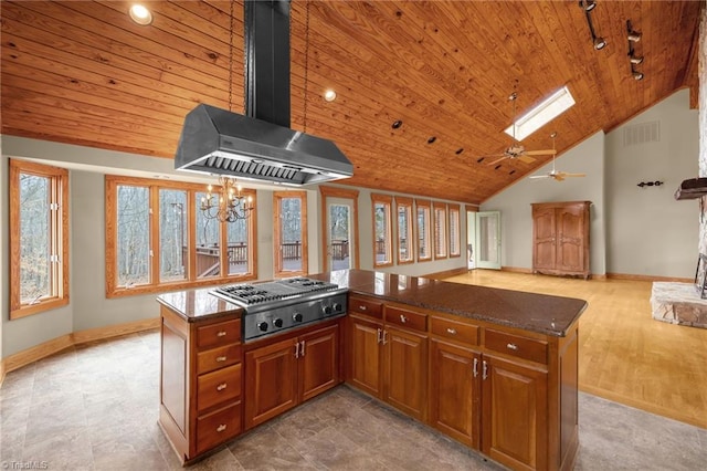 kitchen with wood ceiling, a skylight, range hood, stainless steel gas cooktop, and a kitchen island