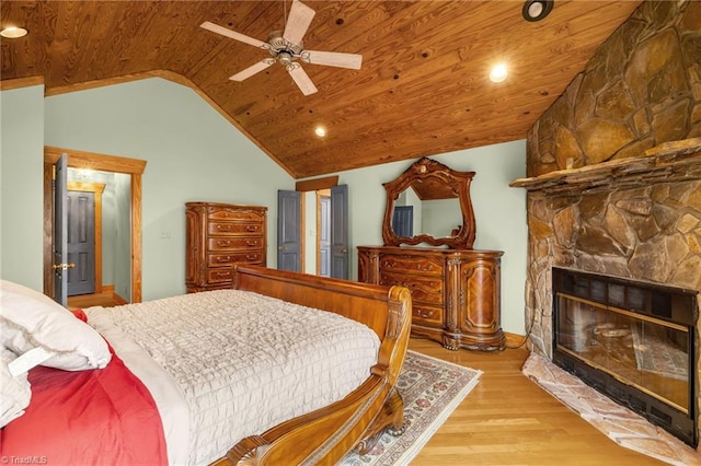bedroom with ceiling fan, a fireplace, vaulted ceiling, wooden ceiling, and light wood-type flooring